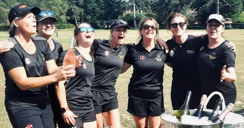 The women's cricket team celebrating on the boundary