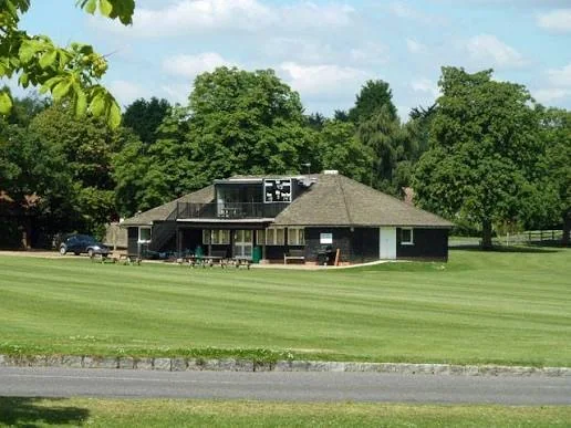 The Pavilion seen across the Green on a summer afternoon, with its balcony overlooking the cricket outfield