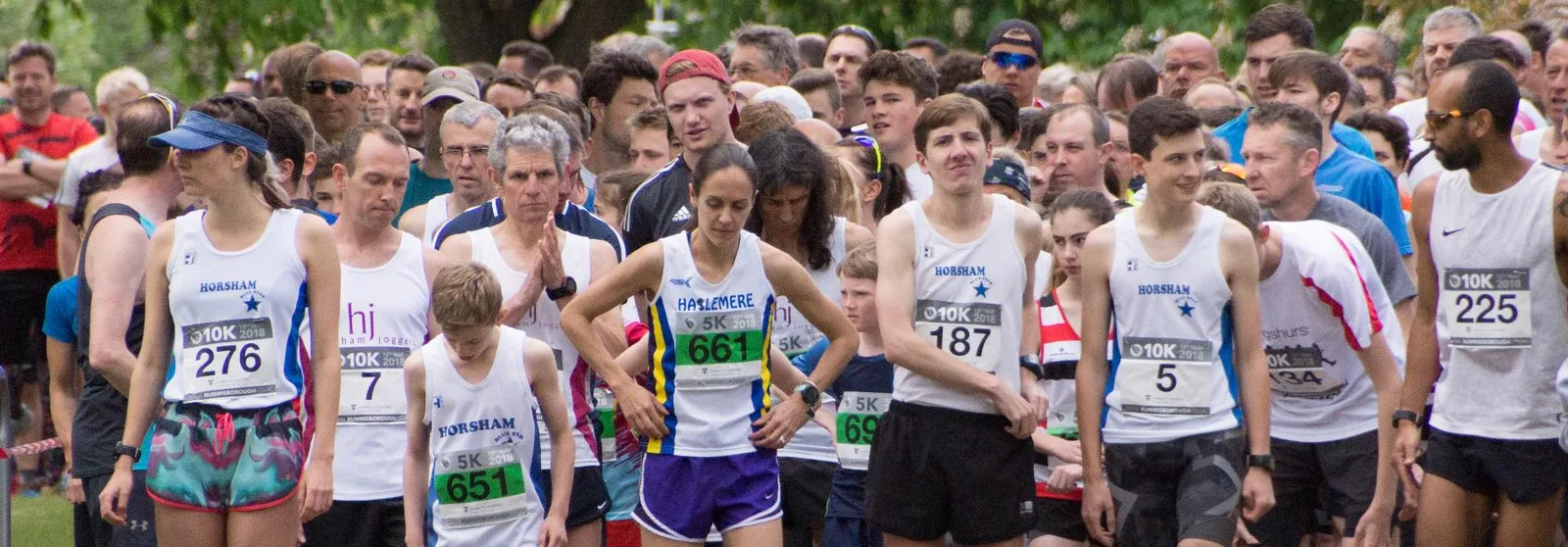 Runners streaming off the RunWisborough start line beneath the trees